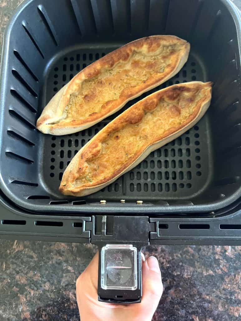 Two Trader Joe’s Garlic Gondolas perfectly cooked and golden brown in an air fryer basket, ready to serve.