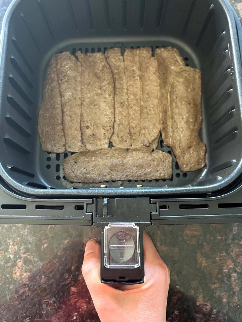 Uncooked Trader Joe’s gyro slices placed in a single layer inside an air fryer basket, ready to be cooked