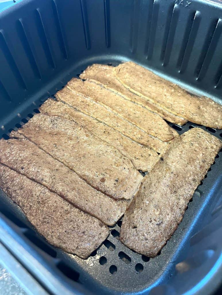 Angled view of Trader Joe’s gyro slices arranged in an air fryer basket before cooking, ready for a quick meal.