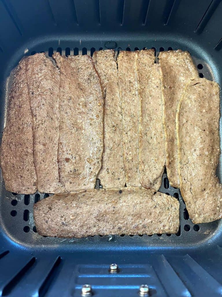 Close-up of Trader Joe’s gyro slices arranged in an air fryer basket before cooking.