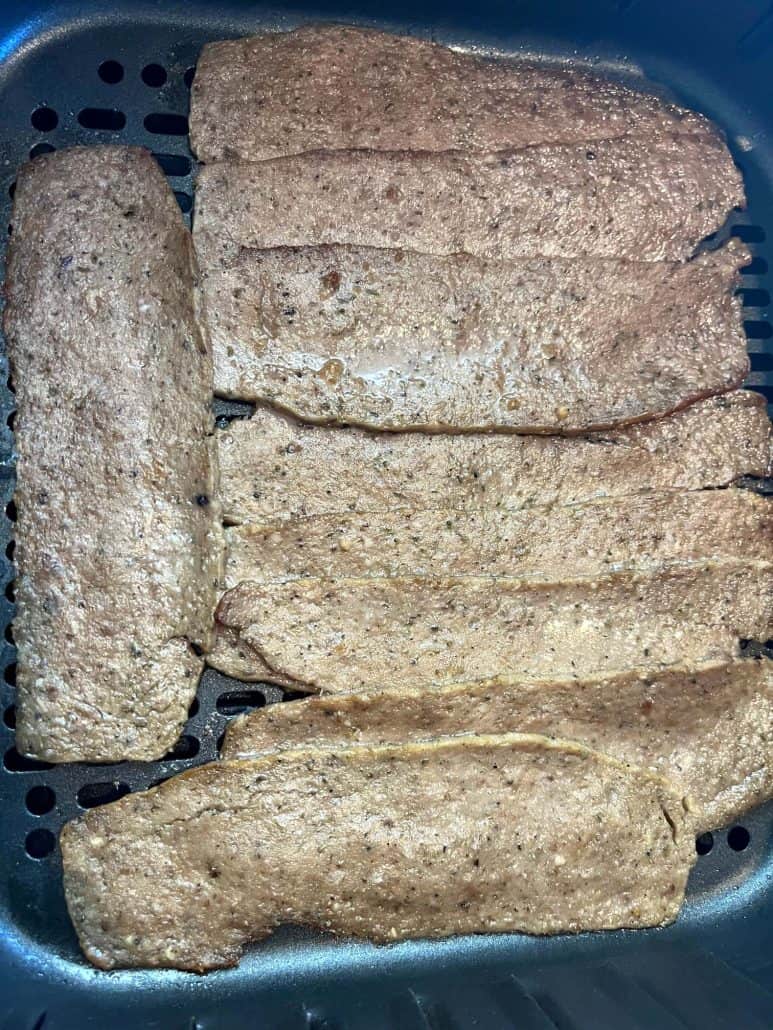 Trader Joe’s gyro slices laid flat in an air fryer basket before cooking for a quick and easy meal.