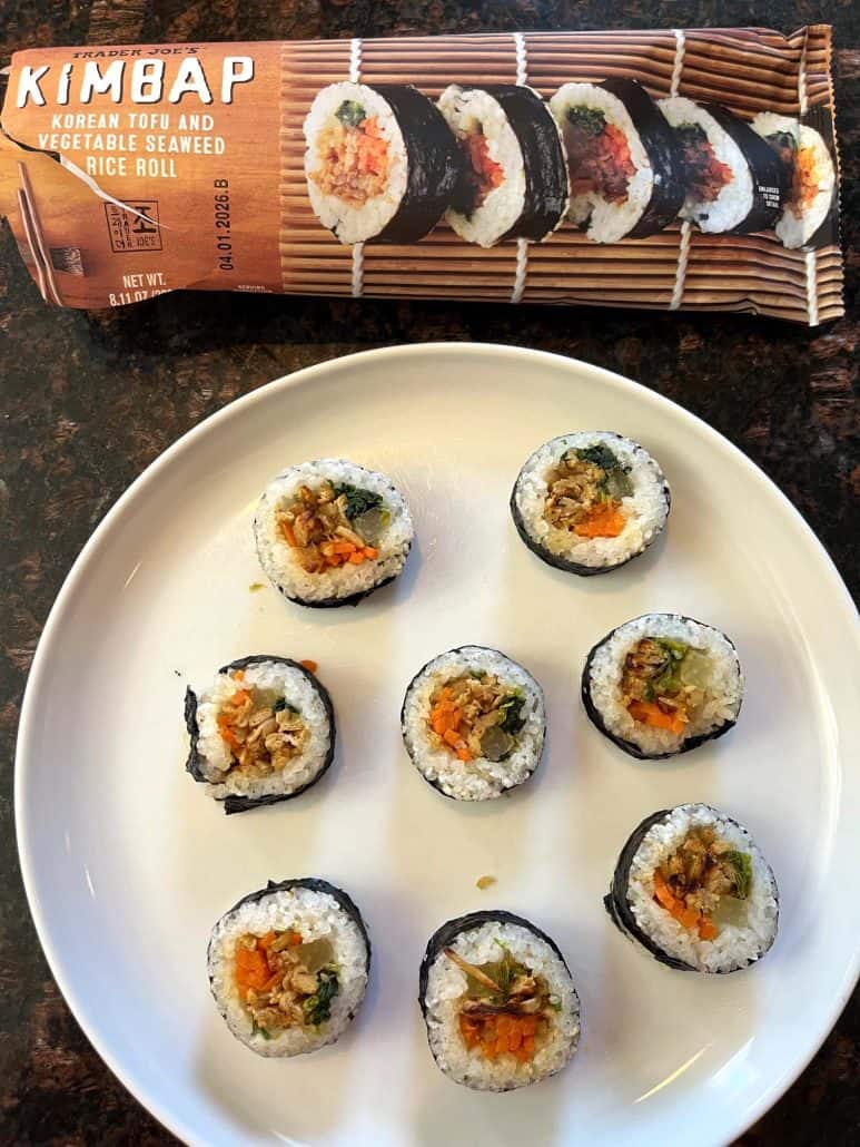 Plate of cooked Trader Joe's kimbap rolls with the package in the background, ready to serve.
