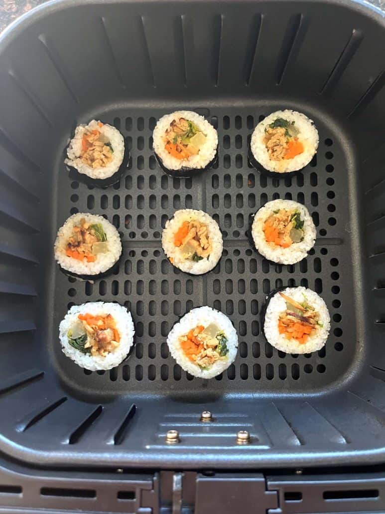 Air fryer basket with Trader Joe's frozen kimbap arranged in a single layer.