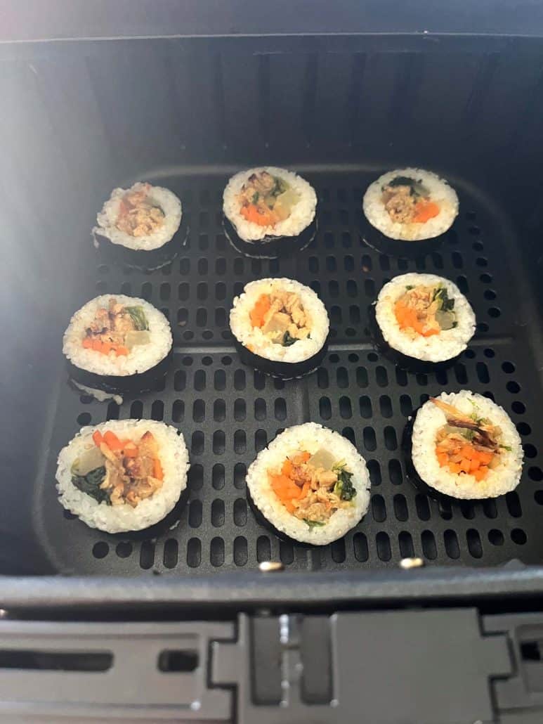 Close-up of Trader Joe's frozen kimbap arranged in a single layer inside an air fryer basket.
