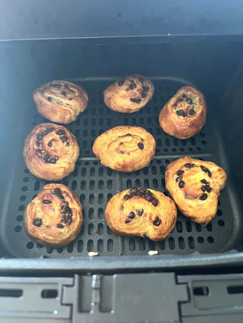 Freshly baked Trader Joe’s Mini Croissants in the air fryer basket, showcasing their golden, crispy texture and melted chocolate chips.