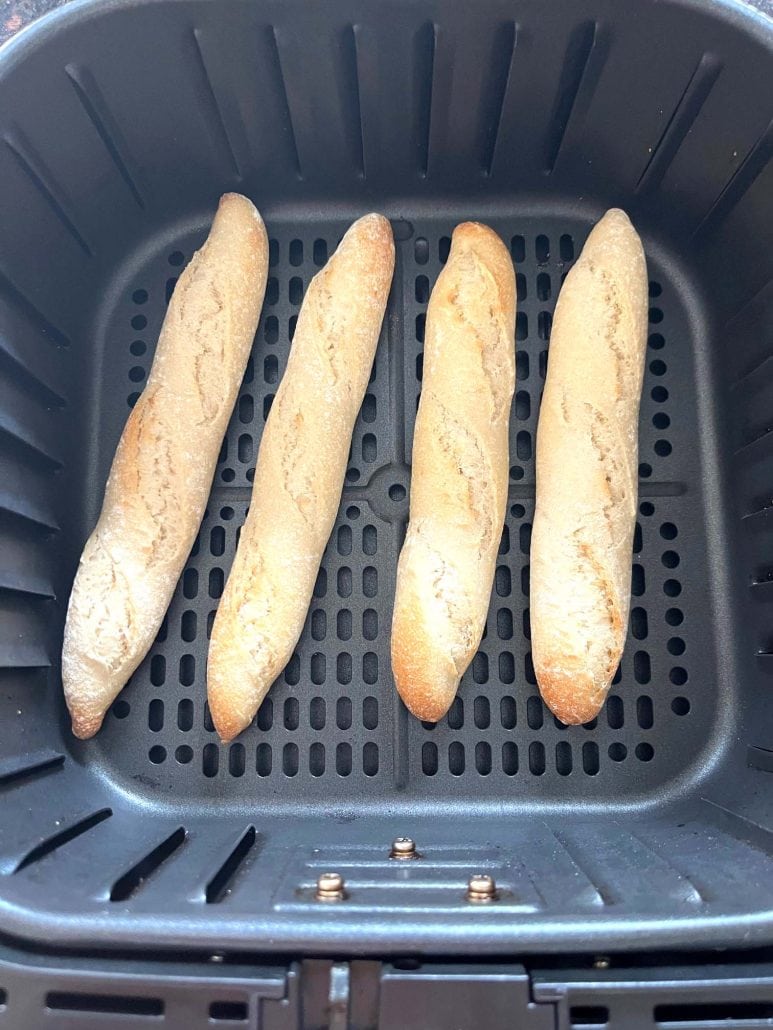 Crispy and golden Trader Joe’s mini French baguettes inside the air fryer basket, freshly cooked.