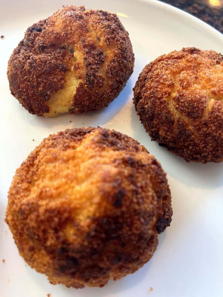 Close-up of crispy, golden Trader Joe’s Papas Rellenas served hot on a white plate.