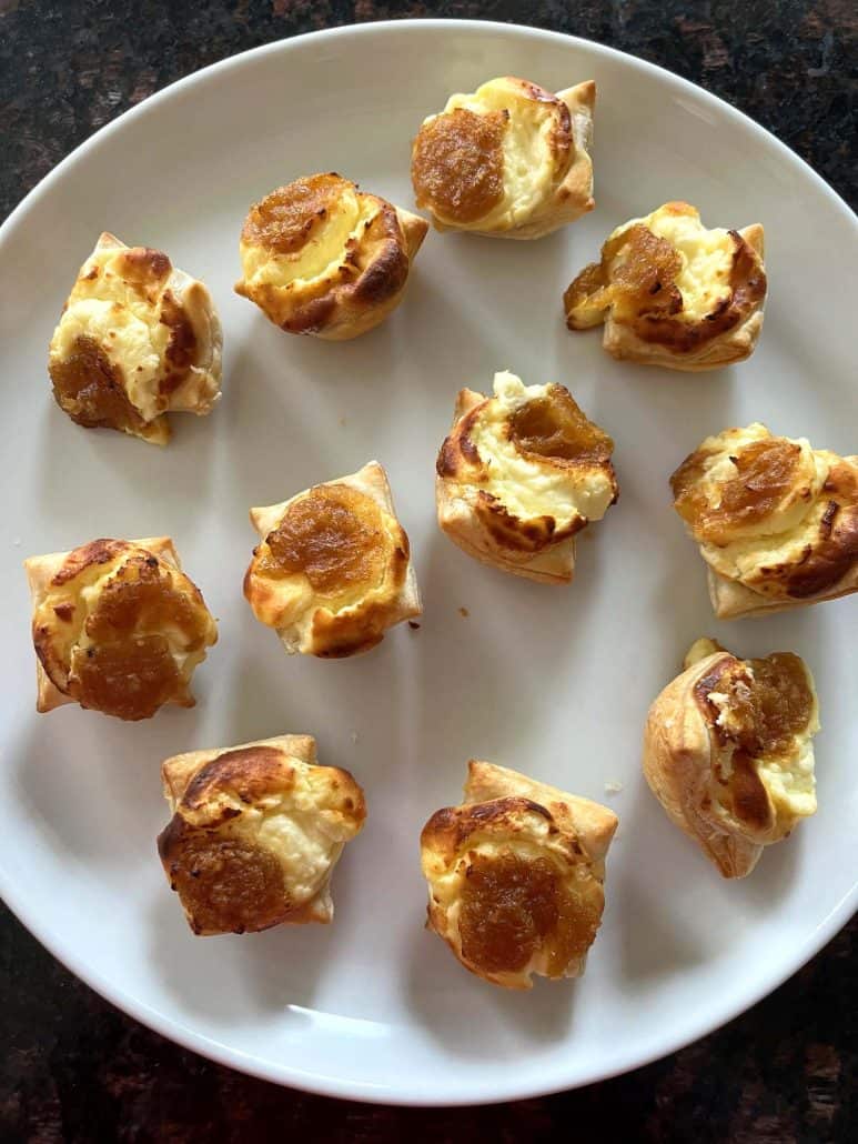 Air fried Trader Joe’s Pastry Bites arranged on a white plate, showing their golden, flaky exterior and melted cheese filling.