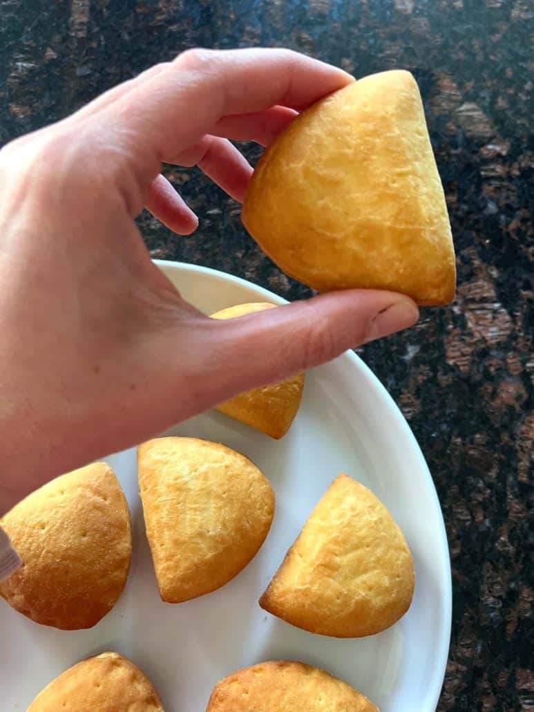  Hand holding a freshly air-fried Trader Joe’s Panzerotti Pizza Bite above a plate.