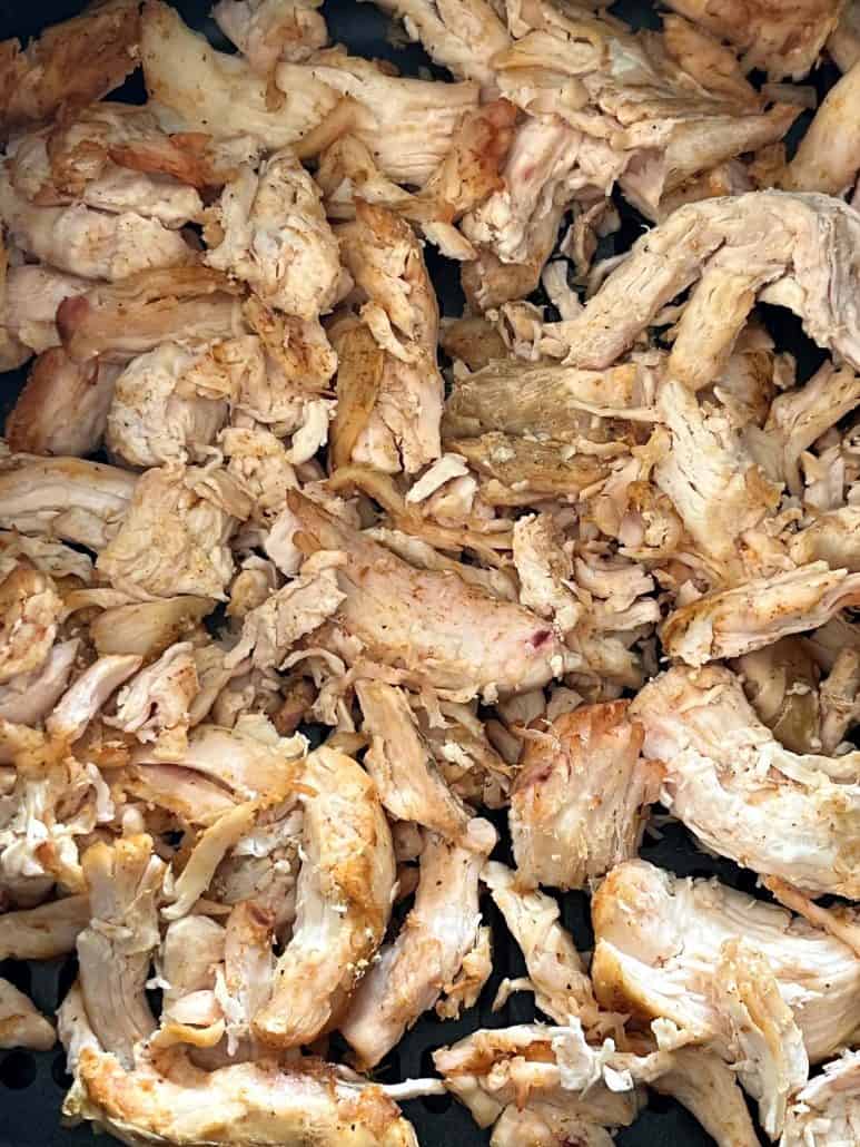 Close-up view of crispy, golden Trader Joe’s pulled chicken fresh out of the air fryer.