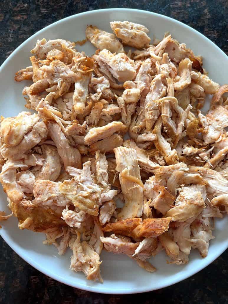 Air-fried Trader Joe’s pulled chicken served on a white plate, showing its golden, crispy texture and ready to eat.