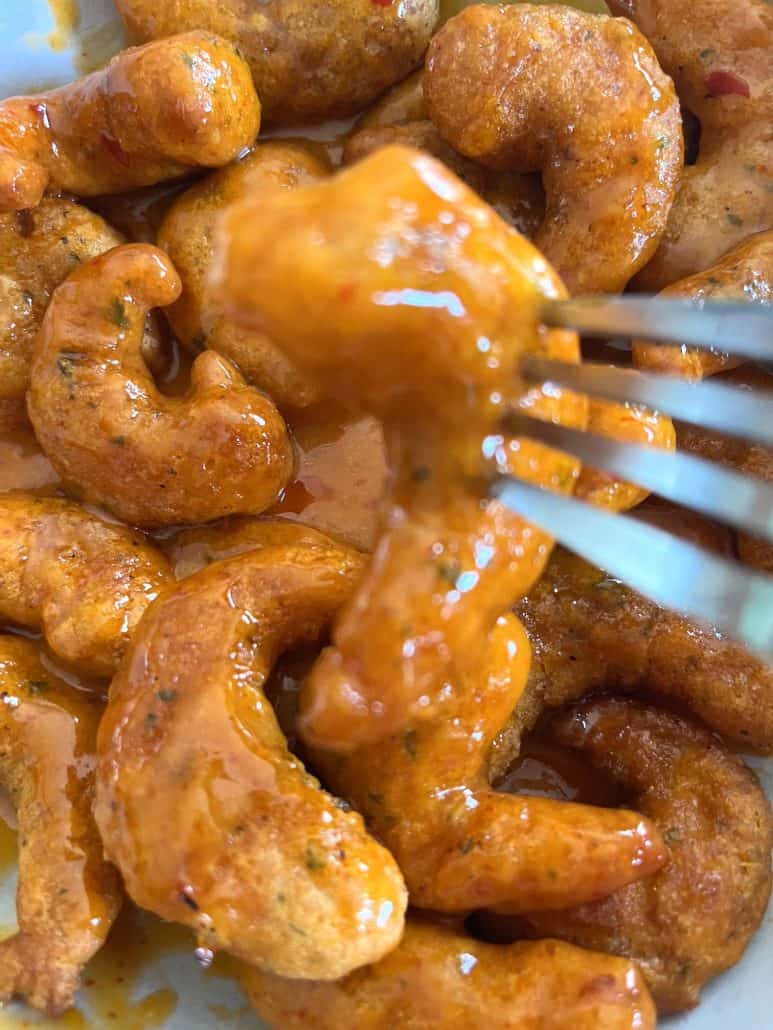 Close-up of fork picking up a saucy piece of Trader Joe’s Shrimp Boom Bah from a bowl.
