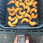 Crispy golden shrimp cooking in an air fryer basket for the Air Fryer Trader Joe’s Shrimp Boom Bah recipe.