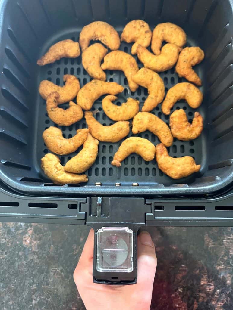 Crispy golden shrimp cooking in an air fryer basket for the Air Fryer Trader Joe’s Shrimp Boom Bah recipe.