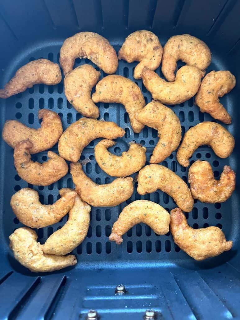 Overhead view of cooked Trader Joe’s Shrimp Boom Bah in an air fryer basket—crispy and ready to be tossed in sweet and spicy sauce.