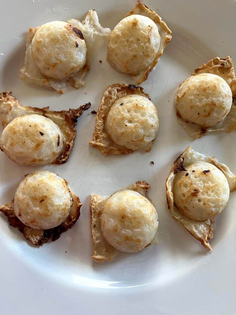 Zoomed-in view of crispy, golden Trader Joe’s Thai Coconut Pancakes (Kanom Krok) served on a plate.