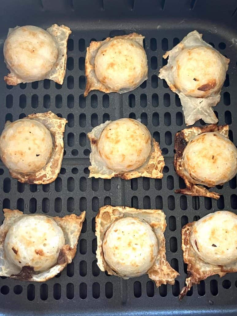 Cooked Trader Joe’s Thai Coconut Pancakes (Kanom Krok) in the air fryer basket, showing their crispy edges and creamy centers.