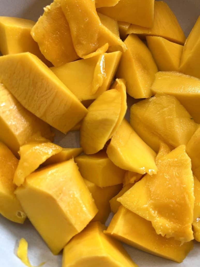 Close-up of freshly cut Philippine Carabao (Manila) mango slices, highlighting their vibrant color and smooth texture from the cutting tutorial.