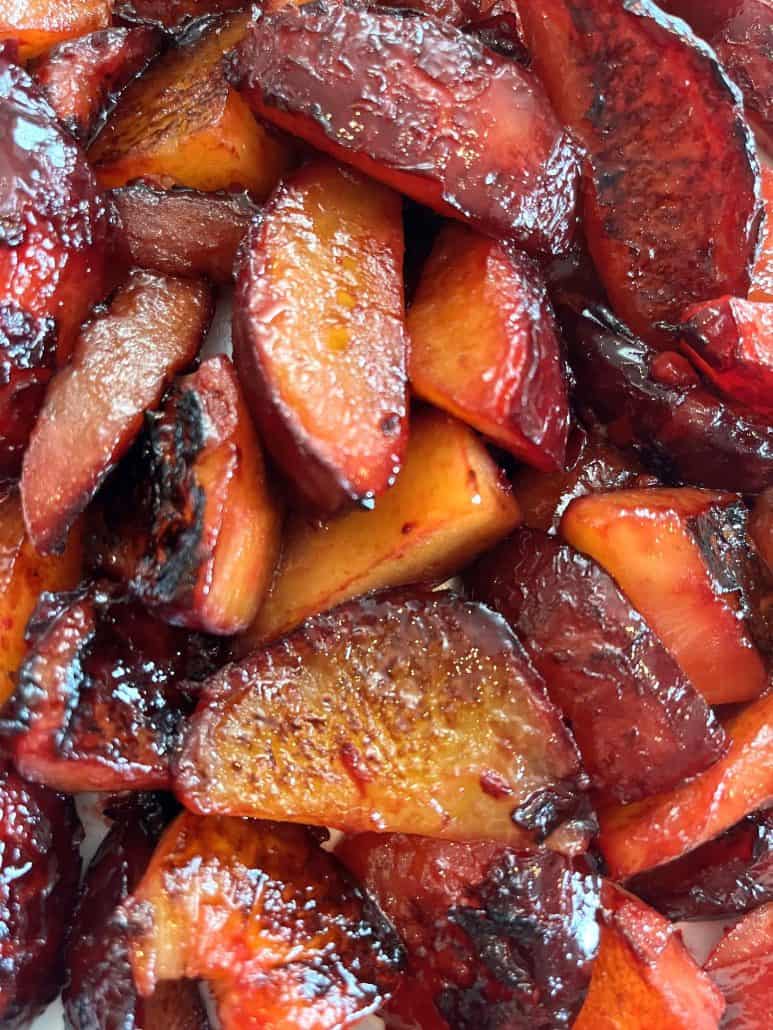 Close-up of warm, glossy caramelized plums showing their rich texture and color from the Sauteed Plums Recipe.