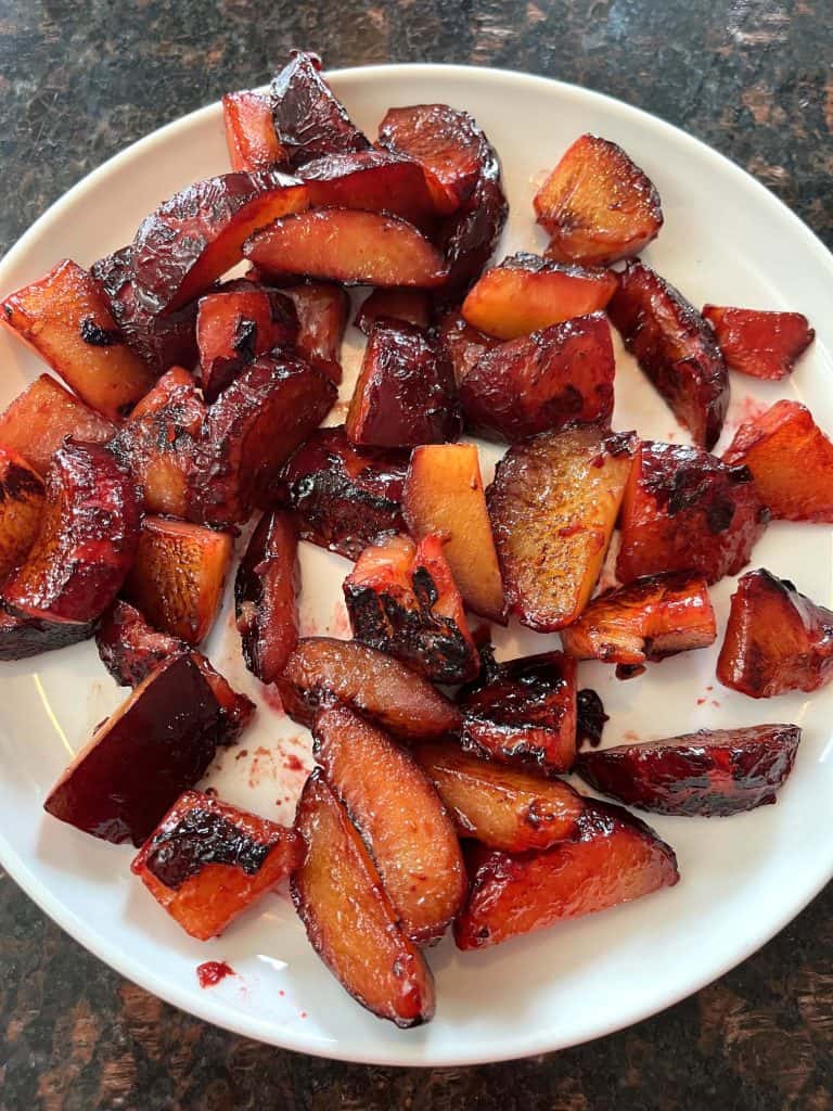 Plate of caramelized sauteed plums cooked on the stovetop, showcasing their rich color and tender texture from the Sauteed Plums Recipe.
