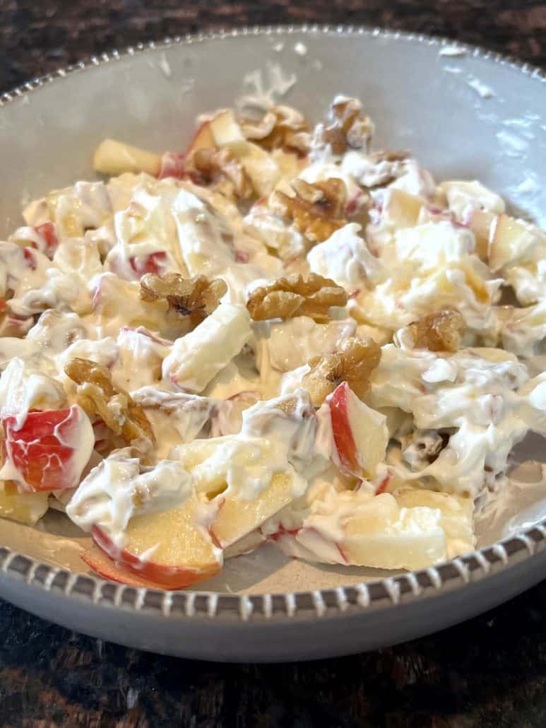 Skyr bowl with diced apples, walnuts, and honey, highlighting the creamy texture and crunchy toppings.