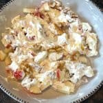 Bowl of apple raisin salad mixed with Greek yogurt, showcasing the creamy texture and fresh fruit ingredients from the healthy recipe.
