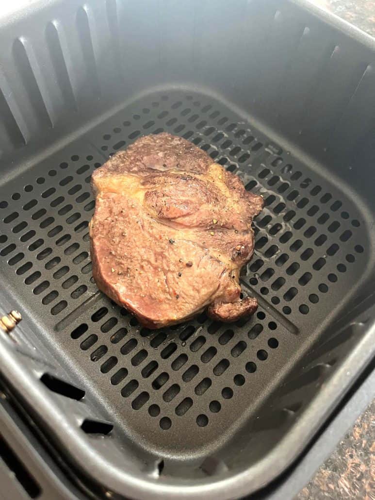Perfectly cooked Delmonico steak resting in the air fryer basket after 10 minutes at 400°F, showing golden-brown sear.