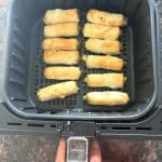 Crispy golden borek bites cooking in an air fryer basket—perfectly cooked.