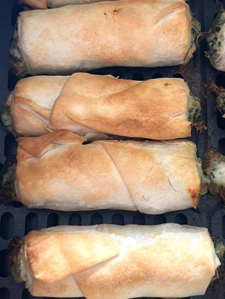 Close-up of flaky, golden air-fried borek bites showing crispy phyllo layers and melted filling.