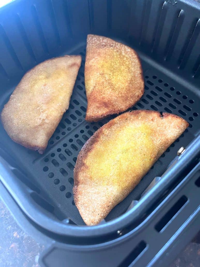 Three golden brown masala dosas in the air fryer basket—crispy and ready to serve.