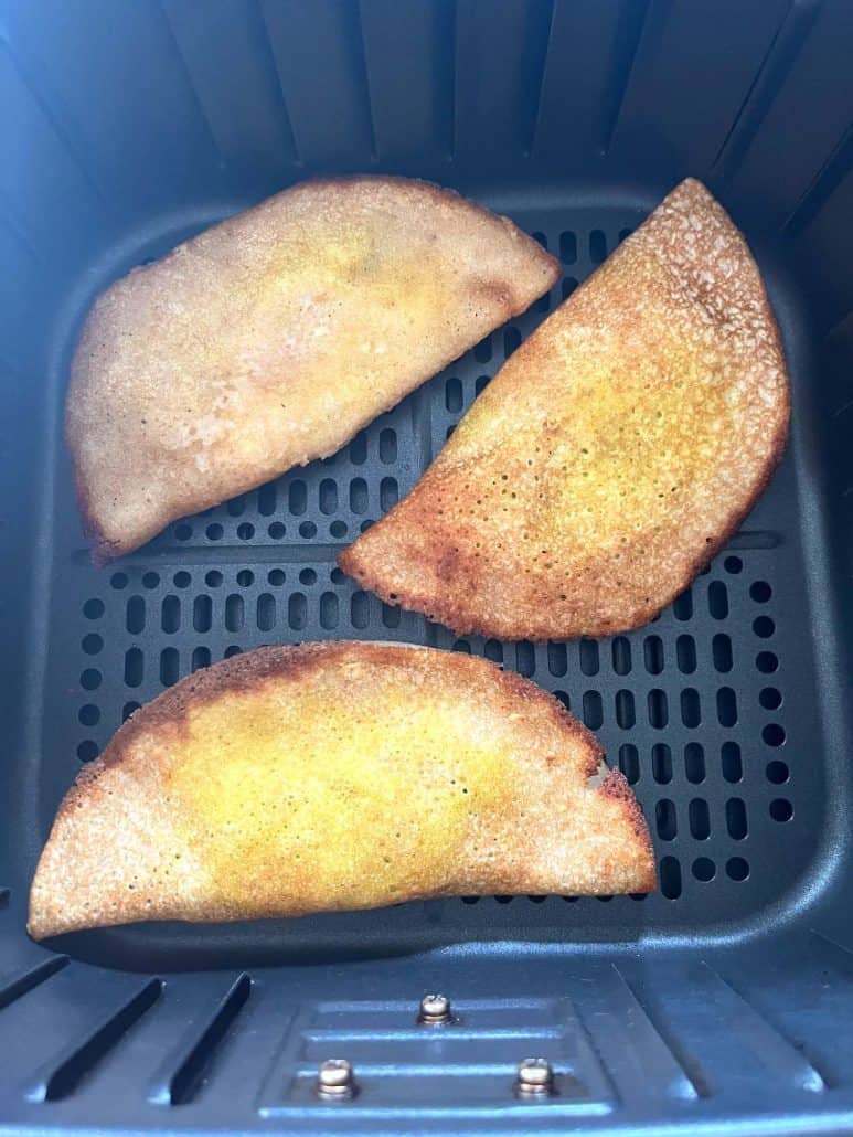Top-down view of three crispy masala dosas cooked in the air fryer basket—showcasing the final result.