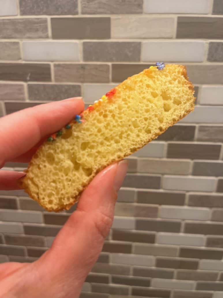 A slice of soft loaf cake, revealing its fluffy texture and colorful sprinkles on top.