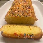 Loaf of cake with colorful sprinkles, sliced to reveal a soft, moist interior. This small cake made with 1 cup of cake mix is a simple, fun treat perfect for celebrations or a quick dessert.