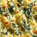 Focus creamy spinach and ricotta stuffed shells baked in a cheesy white sauce.