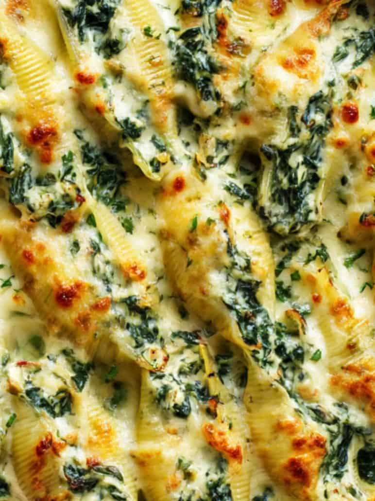 Focus creamy spinach and ricotta stuffed shells baked in a cheesy white sauce.