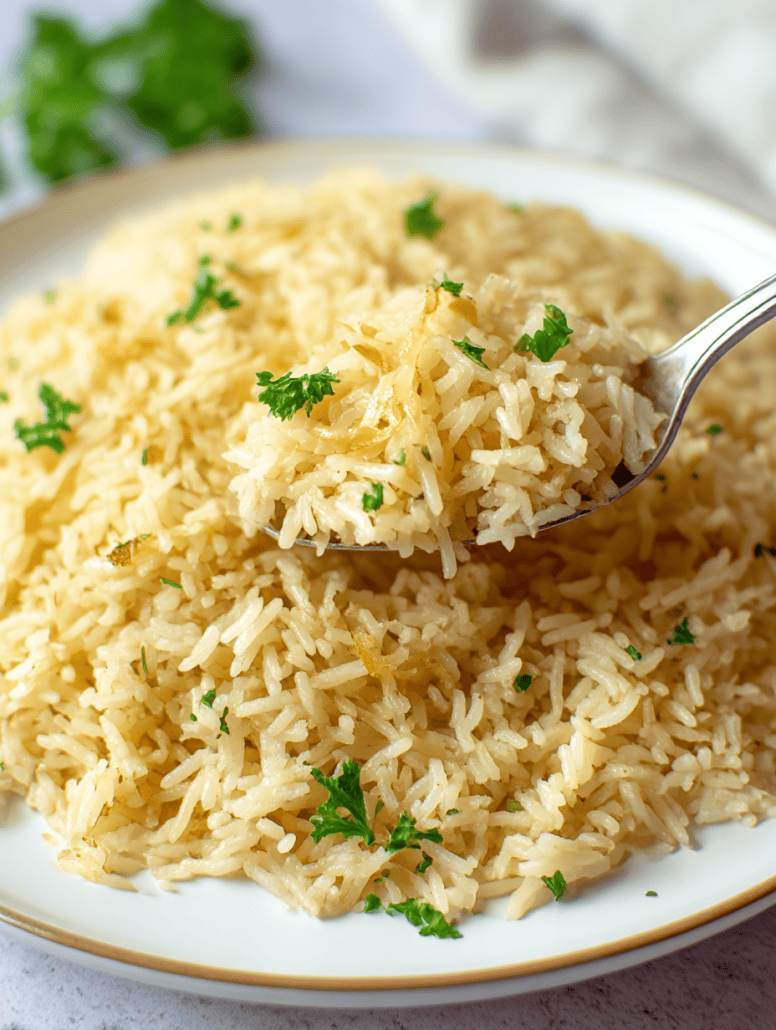 A spoon scooping a serving of fluffy garlic butter rice, garnished with fresh parsley, perfect as a savory side dish.