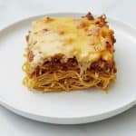 A serving of baked spaghetti, with layers of pasta, ground meat sauce, and melted cheese.
