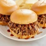 Slow cooker Texas pulled pork sandwiches served on toasted buns with barbecue sauce.