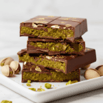 Homemade Dubai chocolate bars filled with crunchy pistachio cream, showing the vibrant green filling and glossy chocolate shell.