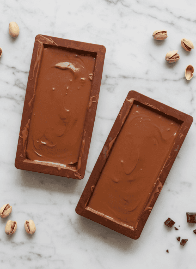 Chocolate-filled molds chilling to set the final layer of homemade Dubai chocolate bars.