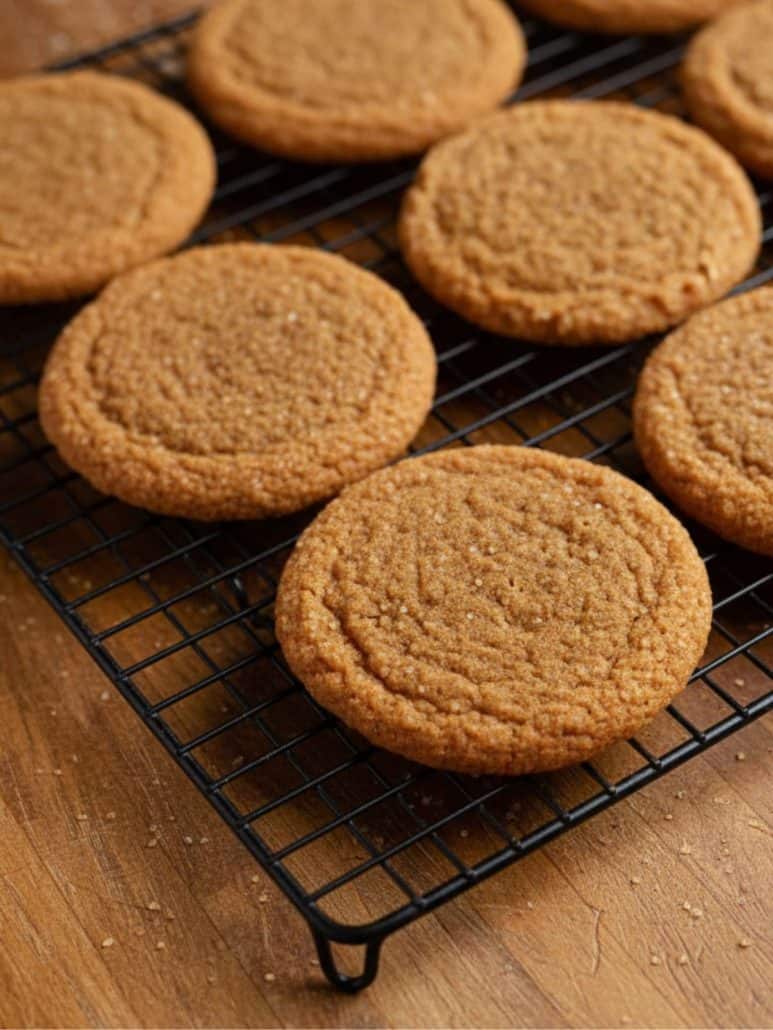 Soft and chewy molasses cookies cooling on a wire rack, just out of the oven.