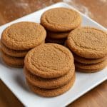 Plate of soft and chewy molasses cookies with crackly tops, perfect for holiday baking or gifting.