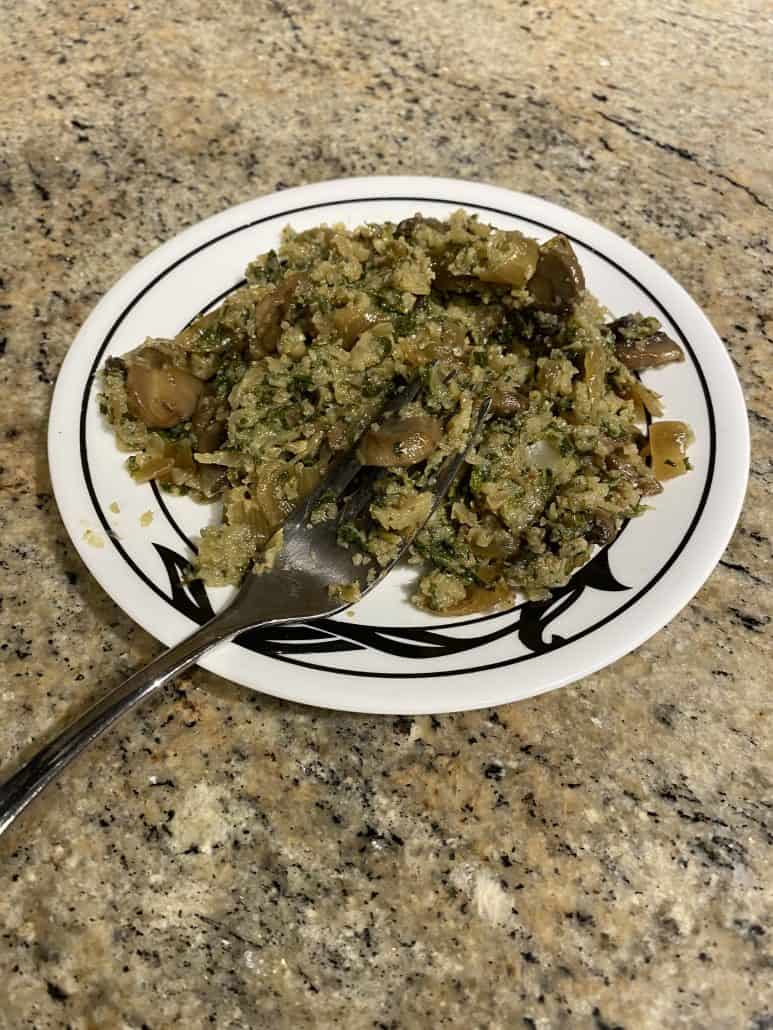 Angle view of Mustard Greens with Mushrooms and Cauliflower Rice served on a plate with a fork – a hearty, veggie-packed stovetop dish perfect for clean eating.