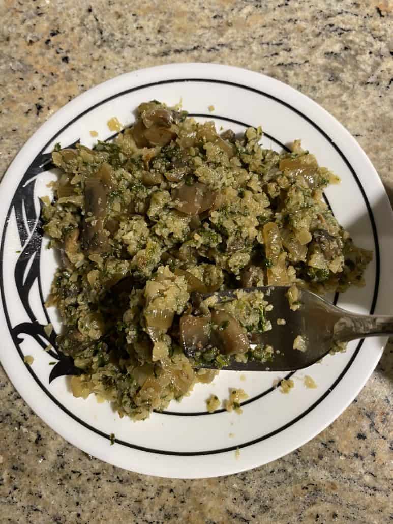 Mustard Greens with Mushrooms and Cauliflower Rice on a plate with a fork.