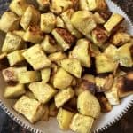 Bowl of oven roasted white sweet potato chunks with golden brown edges, served as a healthy side dish.