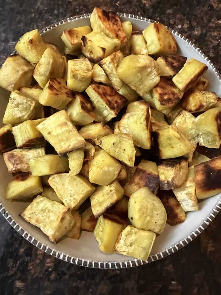 Bowl of oven roasted white sweet potato chunks with golden brown edges, served as a healthy side dish.