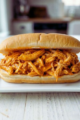 Slow Cooker Shredded Buffalo Chicken Sandwiches Recipe Pulled chicken sandwich on a soft roll, showcasing tender shredded chicken coated in flavorful sauce, perfect for a quick and satisfying meal.