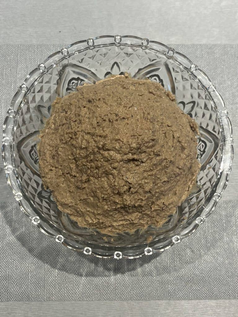 Bowl of creamy chopped liver spread made from sautéed onions and calf liver, ready to serve as a traditional Jewish appetizer.