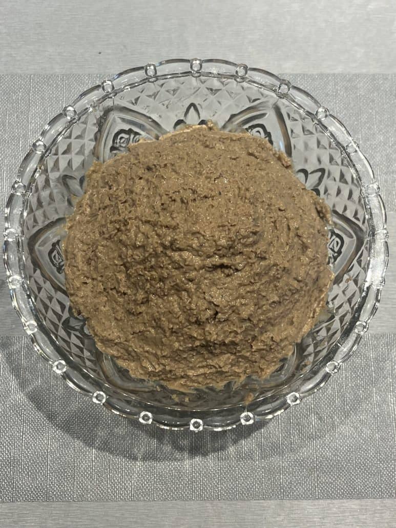 Bowl of creamy chopped liver spread made from sautรฉed onions and calf liver, ready to serve as a traditional Jewish appetizer.