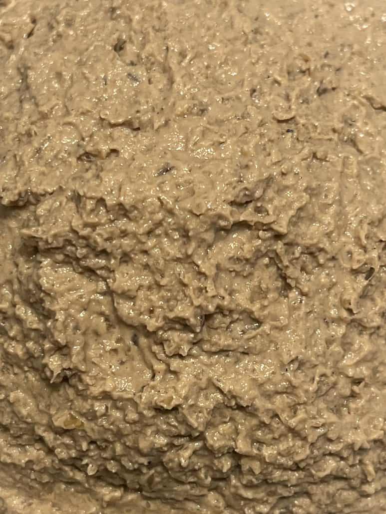 Close-up texture of creamy chopped liver spread, highlighting the smooth and slightly grainy consistency of this traditional dish.